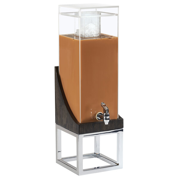 A Cal-Mil Cinderwood beverage dispenser with a brown liquid in a glass container.