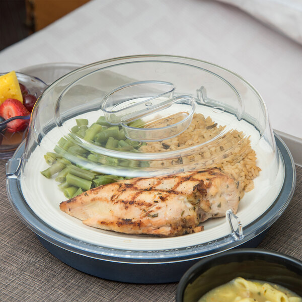 A clear container with a Dinex clear plastic lid covering a plate of food.