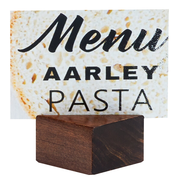 A wooden block with a black diagonal cut card holder with a white menu in it.