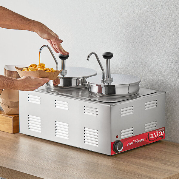 A person using an Avantco countertop food warmer to pour sauce into a bowl of food.