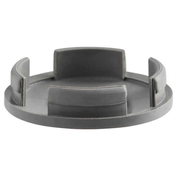 A grey plastic Robot Coupe blade cap with four holes.