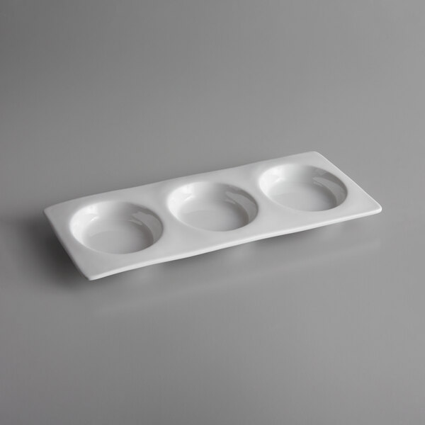 A white porcelain compartment tray with 3 small wells.