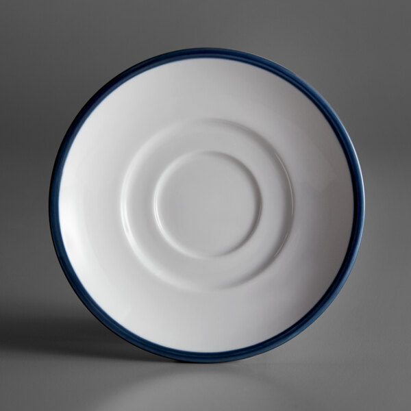 A white porcelain saucer with a circular edge and blue rim.