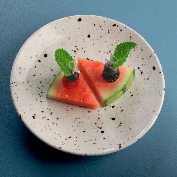 A Elite Global Solutions chocolate chip melamine plate with a slice of watermelon, blueberries, and mint.