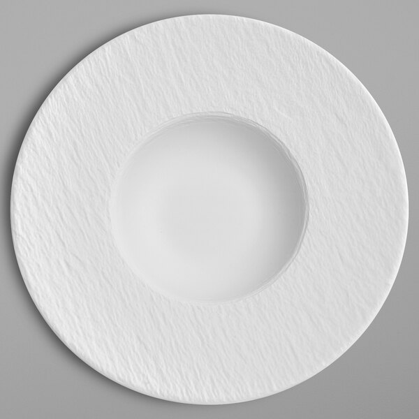 A white porcelain plate with a round center and a circular rim.