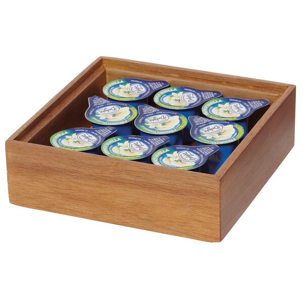A GET Enterprises Urban Rustic wood display box holding small blue containers of yogurt.