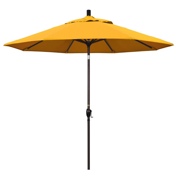 A yellow California Umbrella on a bronze pole.