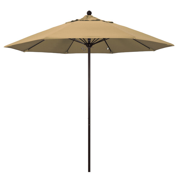 A tan California Umbrella on a bronze pole.