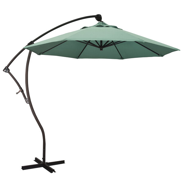 A California Umbrella Bayside cantilever umbrella with green Pacifica spa fabric on a stand.