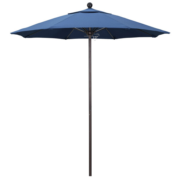 A blue California Umbrella with a bronze pole and a blue canopy.