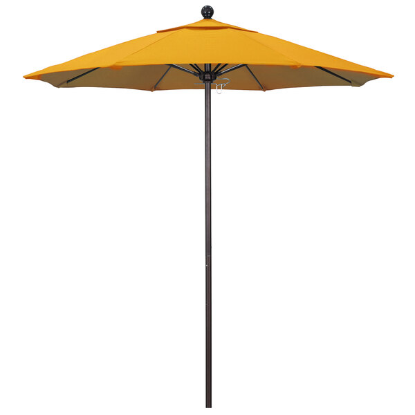 A yellow California Umbrella with a bronze pole.