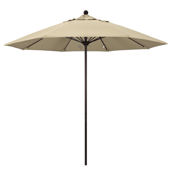 A California Umbrella ALTO round outdoor umbrella with a bronze pole and beige Sunbrella canopy.