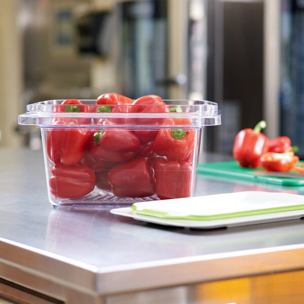 A Rubbermaid plastic container full of red peppers.