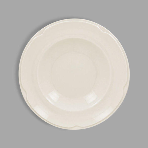 A white porcelain deep plate with a scalloped edge.