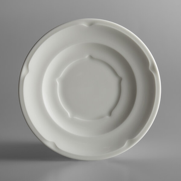 A close-up of a RAK Porcelain ivory porcelain saucer with a circular design.