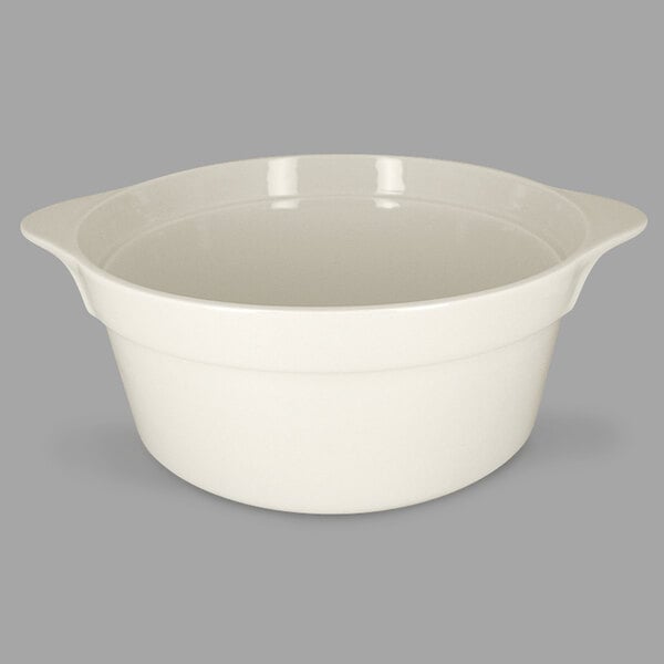 A RAK Porcelain sand white round porcelain cocotte with handles on a grey background.