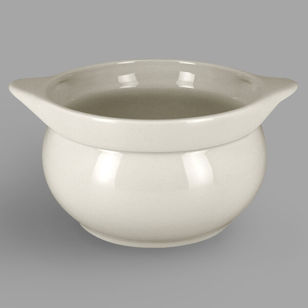 A white RAK Porcelain tureen with a handle and liquid in it.