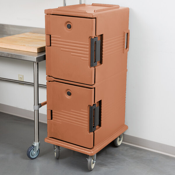 A brown plastic Cambro Ultra Camcart food pan carrier on wheels.