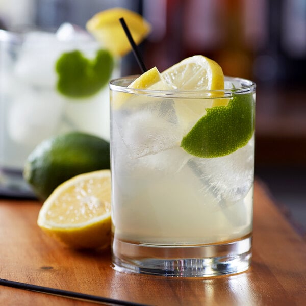 A glass of Monin citrus flavoring syrup with ice and lemon slices.