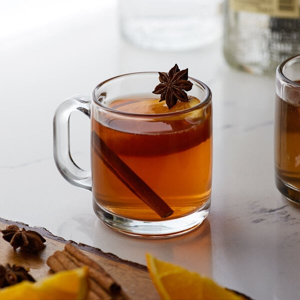 A glass mug of Monin Honey Sweetener tea with cinnamon and anise.