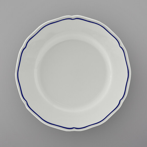 A close up of a Tuxton white china bread and butter plate with blue trim.