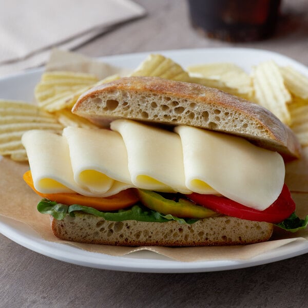 A sandwich with cheese, tomatoes, and vegetables on a plate.
