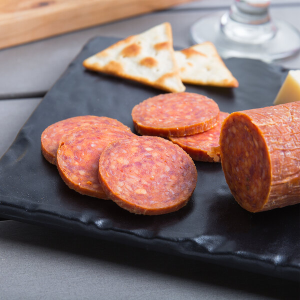 A plate with round slices of pepperoni on it.