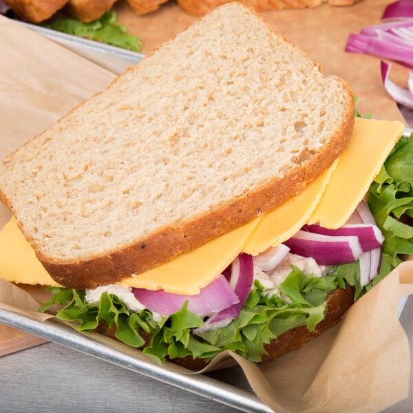 A sandwich with lettuce and Cooper sharp yellow American cheese on a tray.