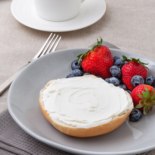 A plate with a bagel with Smithfield Neufchatel Lite Cream Cheese and berries on it.