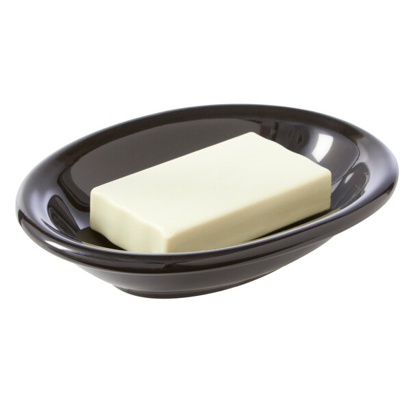 A black gloss ceramic oval soap dish with a bar of soap.