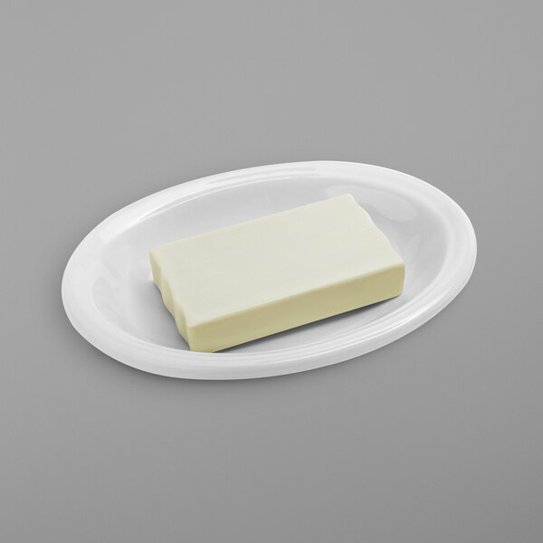 A white rectangular soap dish on a white plate.