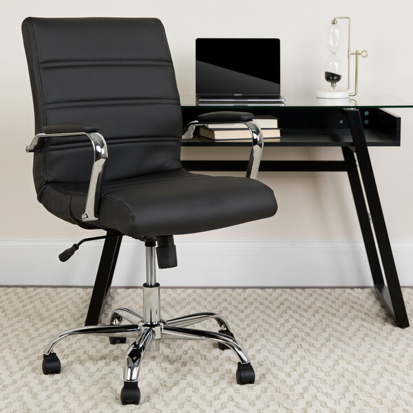A Flash Furniture black leather office chair in front of a desk.