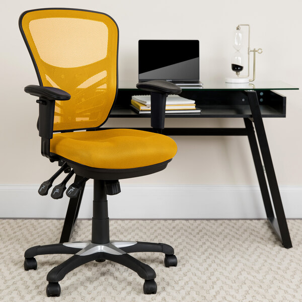 A yellow Flash Furniture office chair next to a black desk.