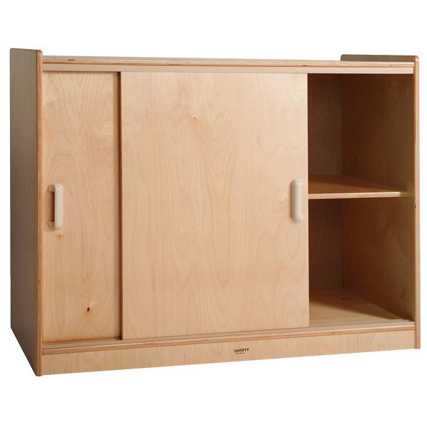 A Whitney Brothers wooden storage cabinet with sliding doors and shelves.