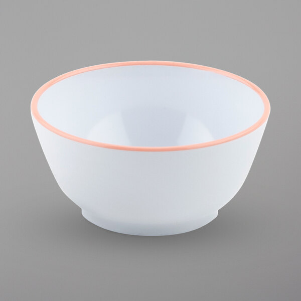 A close-up of a white bowl with pink rim.