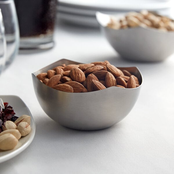 An American Metalcraft stainless steel bowl filled with nuts and dried fruits on a hotel buffet table.