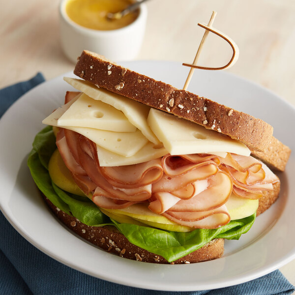 A sandwich with Jarlsberg cheese on a plate.