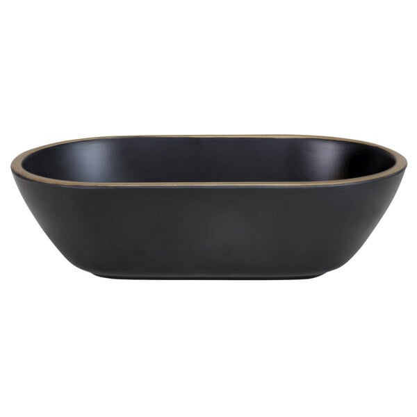 A black oval melamine bowl with a gold border.
