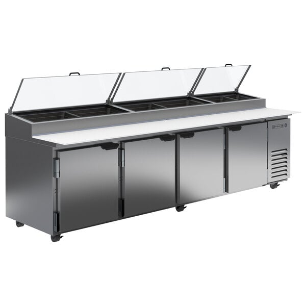 A Beverage-Air stainless steel refrigerated pizza prep table with four clear lids.