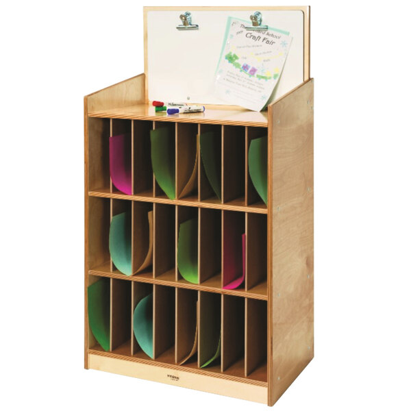 A Whitney Brothers wooden mail and message center with colorful papers and a white board on a shelf.