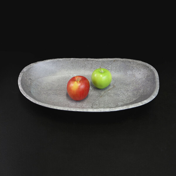 An Elite Global Solutions oval coal melamine bowl with two apples on it.