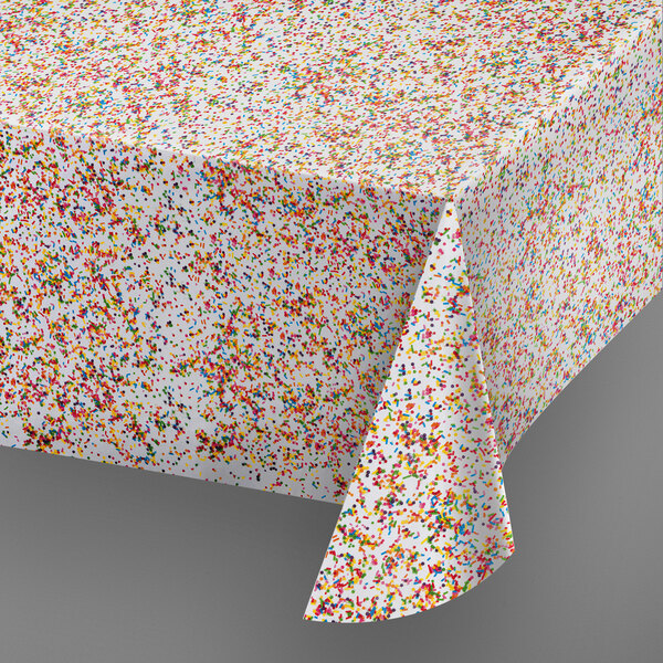 A white tablecloth with multicolored sprinkles on it.