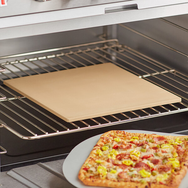 A pizza cooking on an American Metalcraft rectangular ceramic pizza stone in an oven.