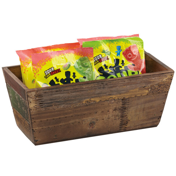 A reclaimed wood rectangular display crate with bags of candy.
