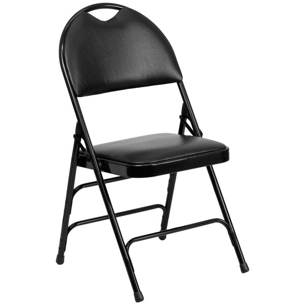 A Flash Furniture black metal folding chair with black padded vinyl seat