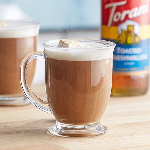 A glass mug of brown liquid with a marshmallow on top using Torani Toasted Marshmallow Flavoring Syrup.