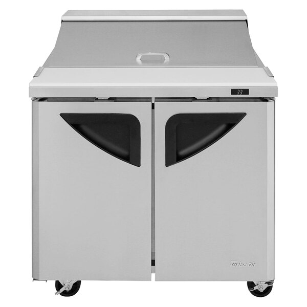 A white stainless steel Turbo Air refrigerator with black handles and two doors.