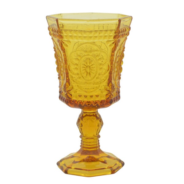 A yellow glass goblet with an ornate pattern.