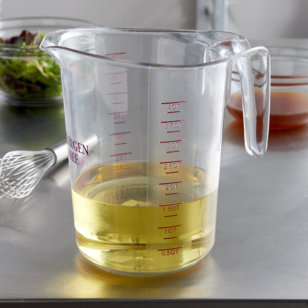 A purple Choice plastic measuring cup with yellow liquid in it.