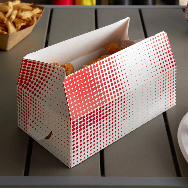 A red plaid and dot take-out lunch box with a fast top on a table with a box of chicken nuggets.